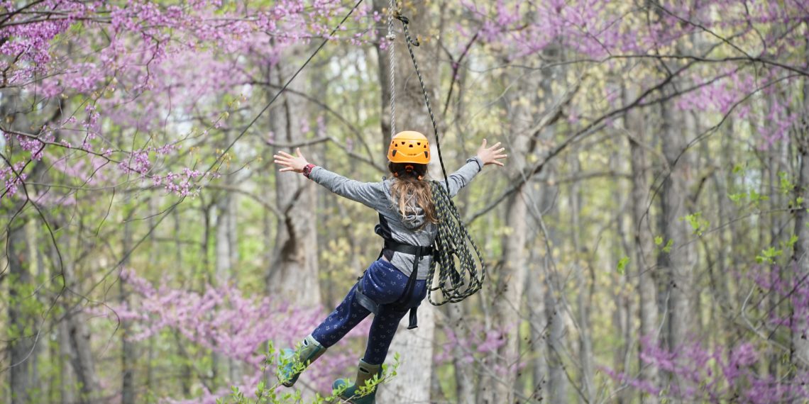 child rides on the zipline at the Outdoor Learning Center at Horizons